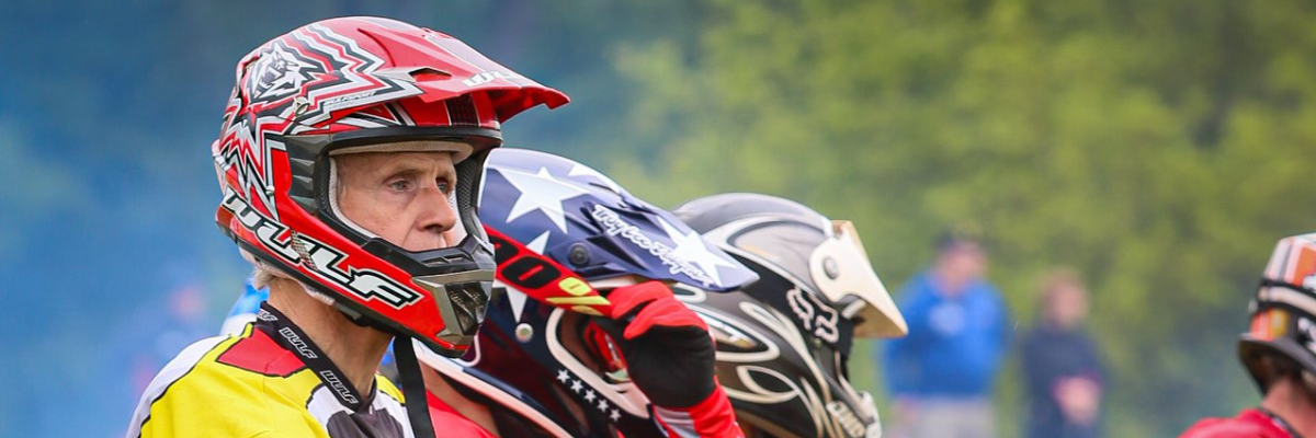 Man on the starting line at a motocross race wearing a red wulfsport helmet