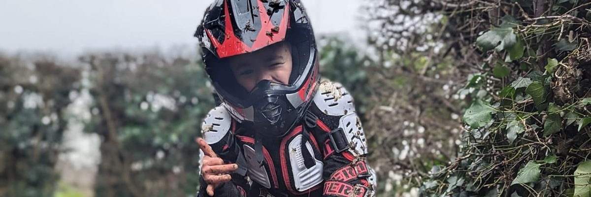Boy wearing a red and black wulf sport helmet and suit