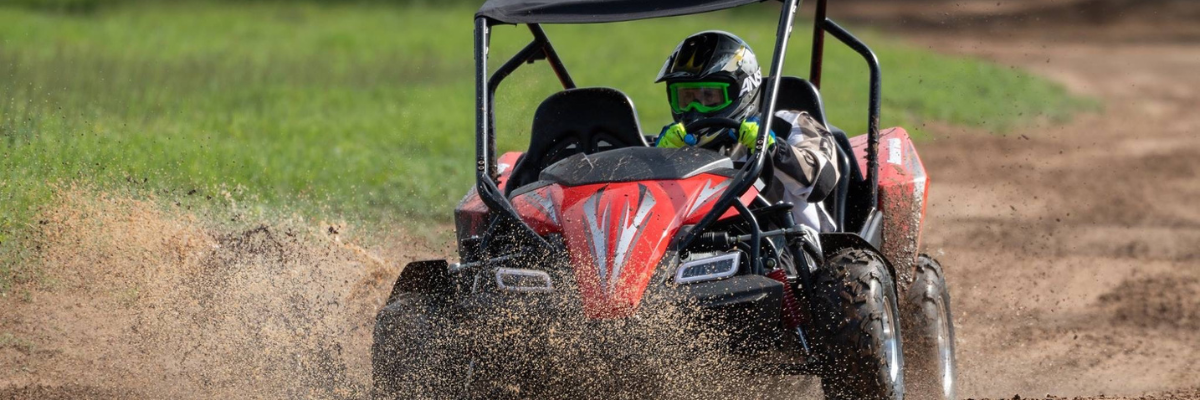 Man driving a red and black GTS150LE Off Buggy on a dirt track